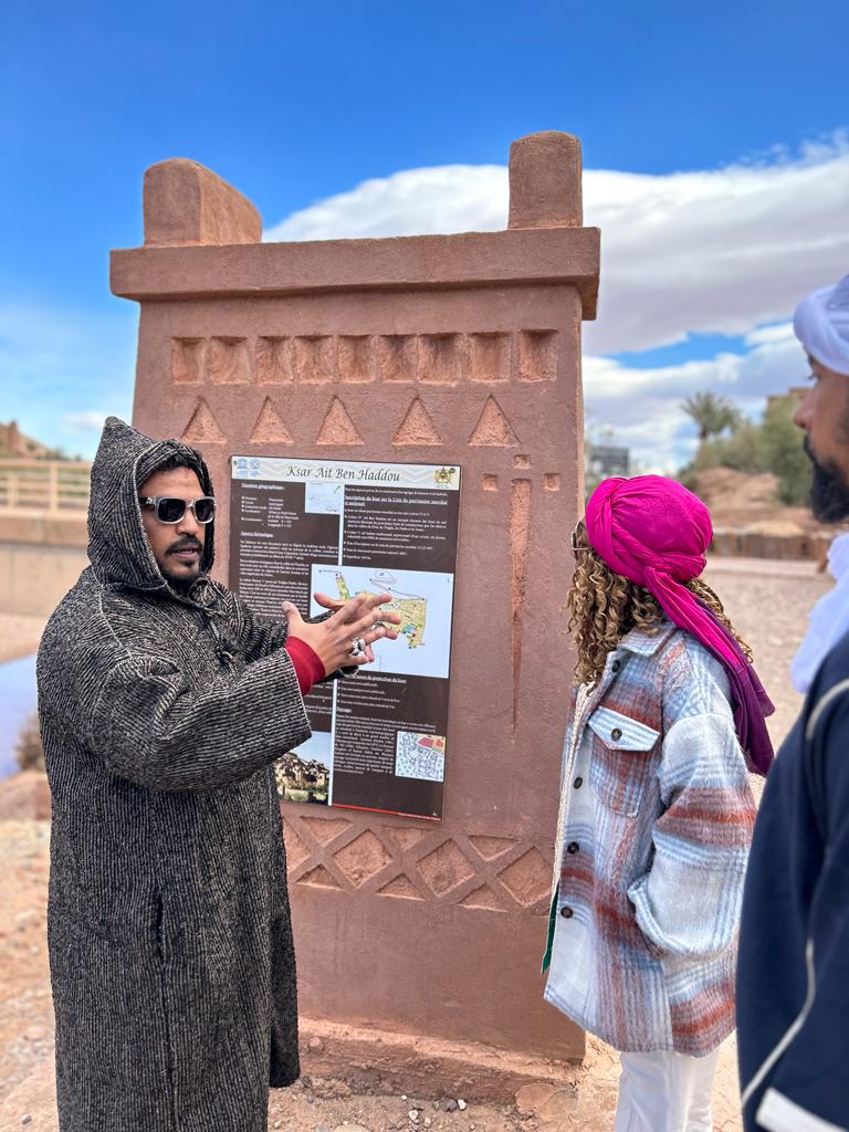 Local guide explaining the day's program to tourists at a historic monument